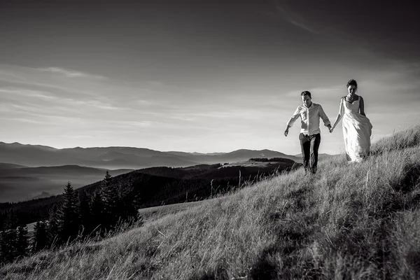 Romantic wedding couple walking in the mountains. Black and white photo