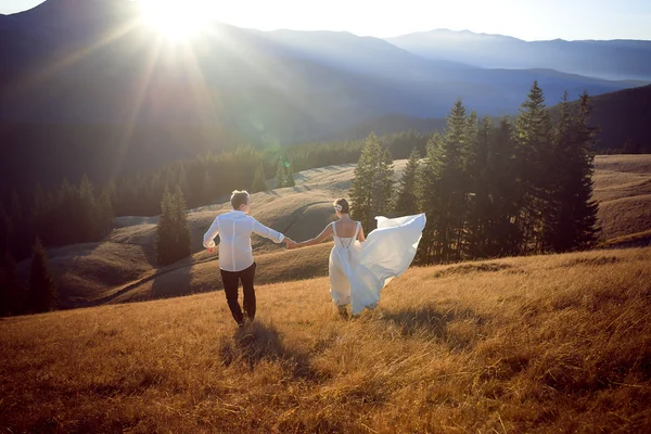 Wedding couple having fun in the mountains. Honeymoon
