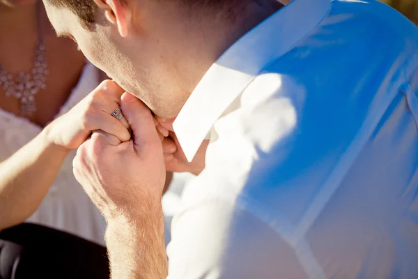 Groom tenderly kisses brides hand close up