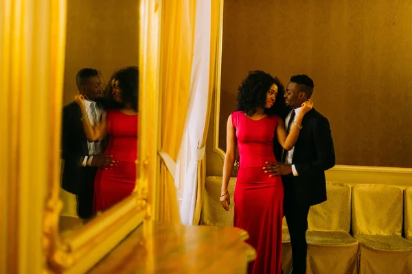 Sexy african women holds in hands her boyfriends face. Luxury theatre interior background