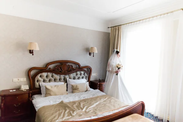 Gorgeous happy luxury stylish bride in white dress and veil near  window on the background of vintage room