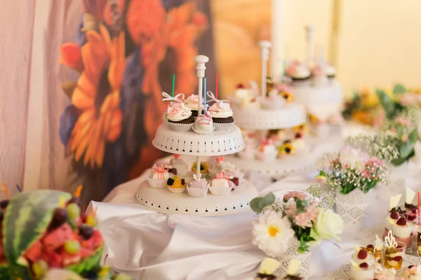 White plate of delicious colorful cupcakes on the wedding table