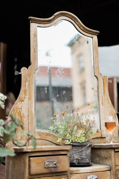 Old vintage dirty wooden mirror decorated with flowers outdoor