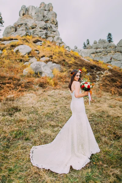 Fashion romantic beautiful bride in luxurious wedding dress. Smiling girl at rocky natural landscape