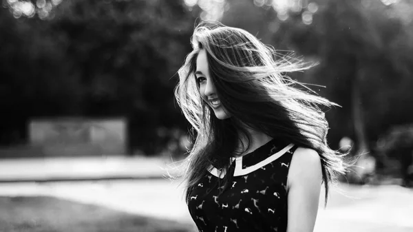 Black and white shot of young beautiful long-haired woman in the city