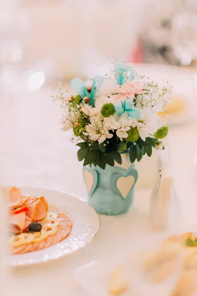 Fancy table setted for a wedding dinner and decorated with flowers in vase