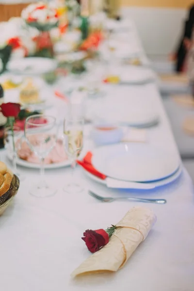 Napkin with rose laying on luxurious served catering dinner table