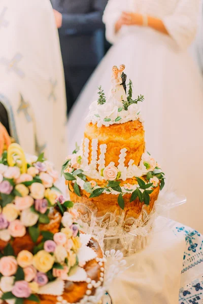 Beautifully decorated traditional wedding bread with blurred couple on background