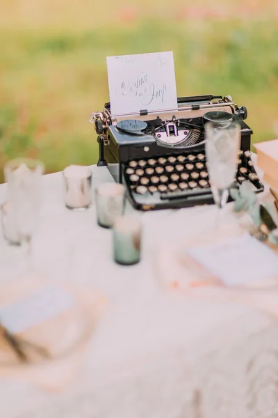 Serving with vintage typewriter and spring flowers at wedding in the forest