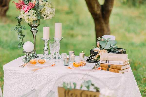 Wedding table decorated with old typewriter vintage ornaments and vases of dried flowers