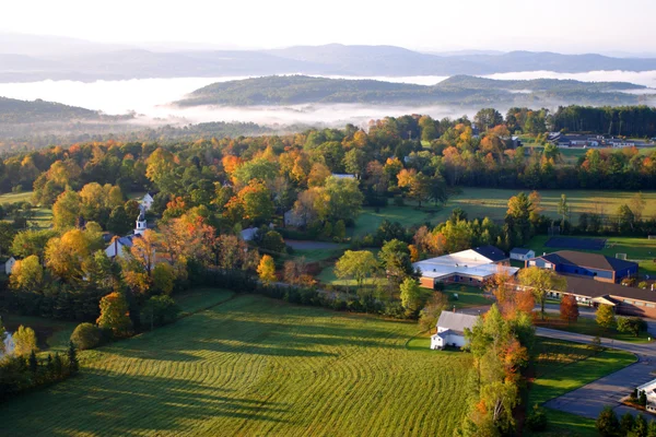 An aerial view of a hot air balloon floating over the Vermont countryside