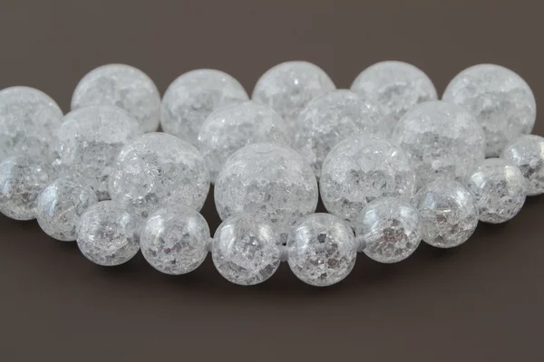 Crackle glass or Sugar quartz beads on a brown background
