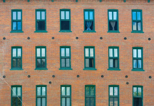 Brick wall and windows facade of urban apartments