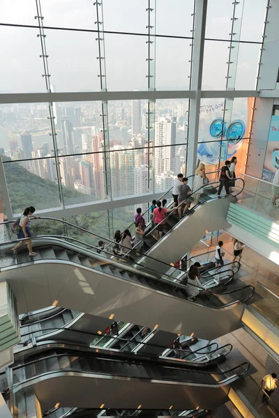 People riding on escalators in a busy peak mall in Hong Kong