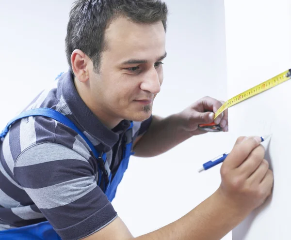 Handyman measuring the wall