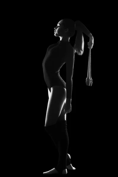 Fitness, sport, people and healthcare concept - Young cute woman in gymnast suit show athletic skill on black background