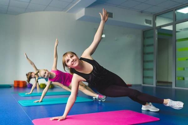 Girls and Instructor or mother doing gymnastic exercises  in fitness class