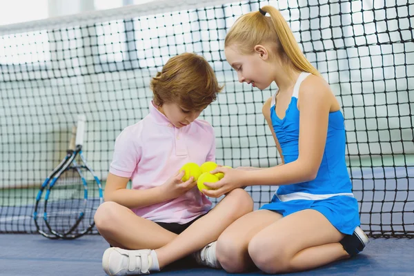 Children having fun and resting on the tennis court