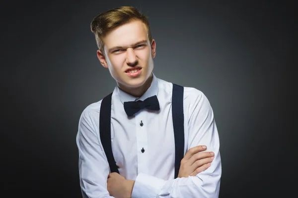 Portrait of angry boy isolated on gray background. Negative human emotion, facial expression. Closeup