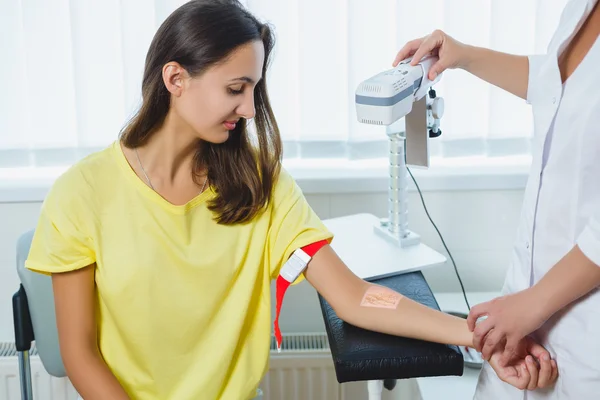 Nurse with the device shows the veins at the doctor office