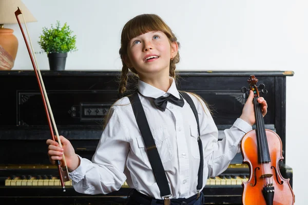 Inspired and happy girl holding a violin indoor