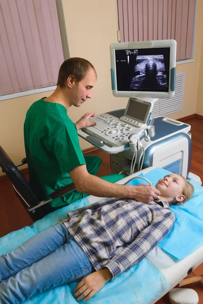 Girl getting ultrasound of a thyroid from doctor