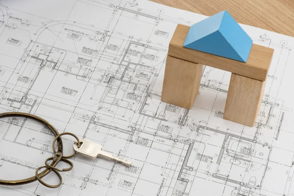 House plan with toy wood block model and a key with vintage ring