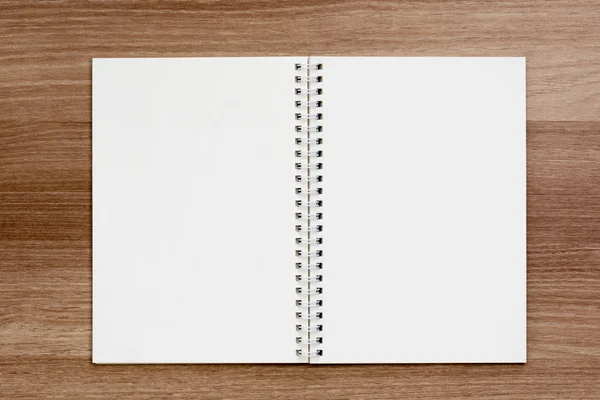 Opened blank ring spiral binding notebook on wooden surface
