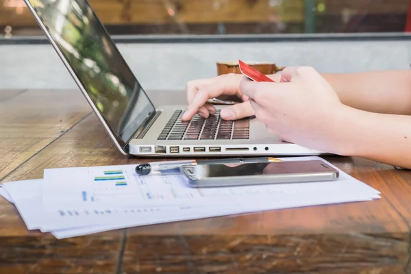 Businessman entering information from a credit card using laptop