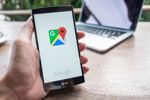 CHIANG MAI, THAILAND - APR 28, 2016: Man hand holding LG G4 with Google Maps application o. Google Maps is a service that provides information about geographical regions and sites around the world.