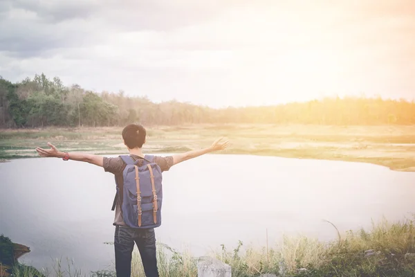 Freedom traveler man standing and enjoying a beautiful nature. Image with vintage filter