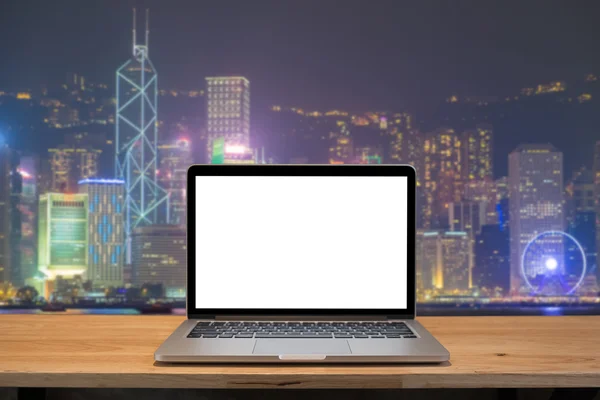 Laptop with blank screen on table. hongkong night city backgroun