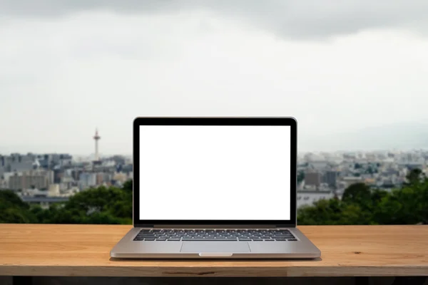 Laptop with blank screen on table. Osaka japan background.
