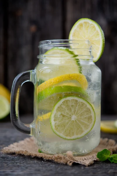 Mineral water with a fresh lemon, a lime and mint. Detox water. Homemade lemonade