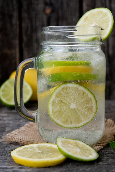Mineral water with a fresh lemon, a lime and mint. Detox water. Homemade lemonade