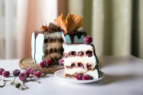 Cut cherry cake decorated with waffles and caramel on a dark wooden background