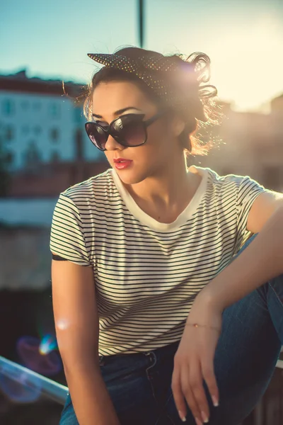 Stylish hipster girl in the denim and sunglasses in the city