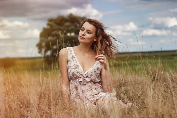Sensual romantic girl with the flowers in the field