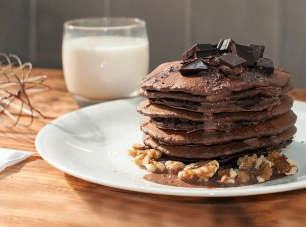 A stack of chocolate pancakes decorated with liquid chocolate sauce