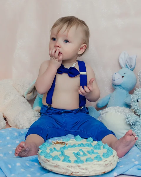 Happy baby boy eating cake for his first birthday party