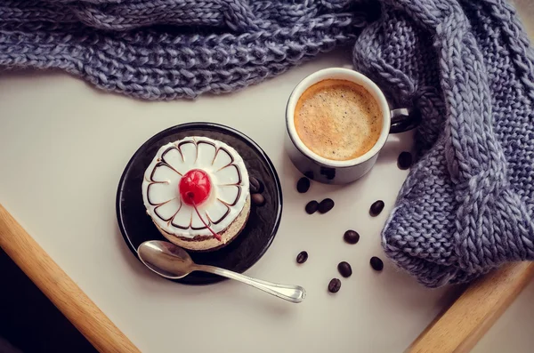 Sweet cake with a cherry and cup of coffee