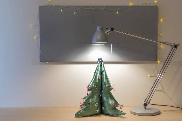 Christmas tree on desk with silver board and lamp