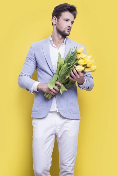 Man holding yellow tulips