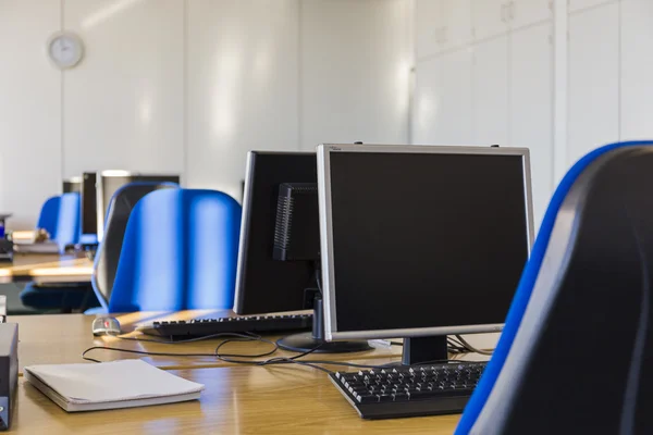 IT room with blue chairs and PC monitors