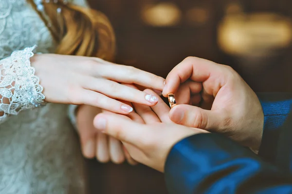 The groom wears the ring bride.