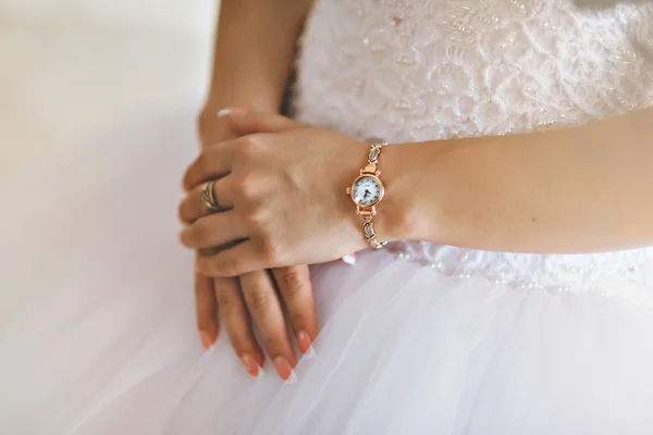 Hands of the bride and white bride dress