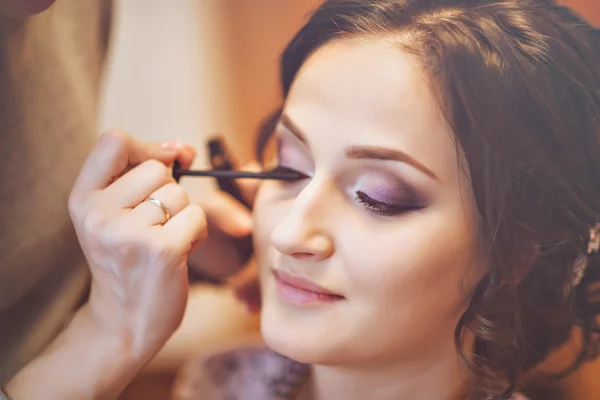 Backstage scene: Professional Make-up artist doing makeup for women