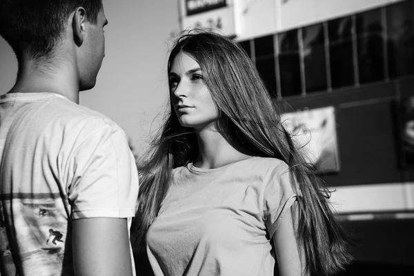The girl looks at the guy. Black and white photo