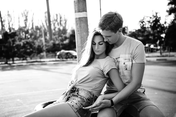 Loving couple sitting at the street on the sunset. Black and whi
