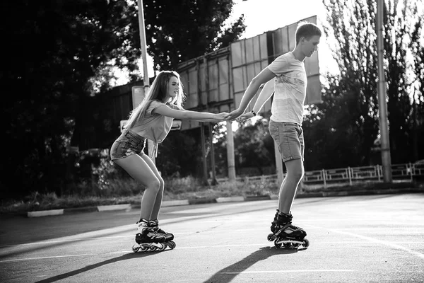 A couple roller-skating at sunset. Black and white